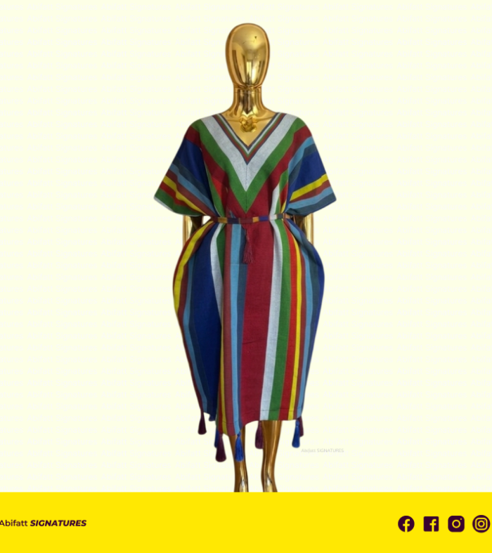 A Celebration of Color and Structural Grace. Command the room with The Zenith Prism Kaftan, a breathtaking fusion of traditional textile artistry and avant-garde silhouette. This piece is designed for the woman who views fashion as a form of personal expression—bold, vibrant, and entirely unique. The Zenith stands out for its masterful use of geometric alignment, featuring a sharp "V" focal point that draws the eye and creates a stunning sense of balance. Design Highlights: Sculpted Silhouette: The unique cinched-waist design creates a dramatic "tulip" drape at the hips, offering a modern, architectural take on the classic kaftan. Prismatic Palette: A vibrant array of vertical stripes including primary reds and blues, grounded by forest green and accented with high-contrast yellow and silver. The "V" Focal Point: The neckline is defined by a bold, chevron-style pattern that elongates the frame and adds a layer of sophisticated geometry. Artisanal Finish: Hand-tied silk tassels in deep sapphire and royal purple weight the hemline, providing a graceful, rhythmic swing with every movement. Style Tip: Because of the structured volume at the hips, keep your silhouette sleek. Pair with tall, minimalist heels to accentuate the length and a sleek updo to showcase the intricate neckline. Fabric & Care: Material: 100% Premium hand-woven cotton blend for a breathable yet substantial feel. Care: Due to the delicate nature of the hem tassels and the intricate weave, professional dry cleaning is recommended. Store on a wide-shoulder hanger to maintain the sculpted shape. Elevate your vibration. Wear the rainbow. Own The Zenith.